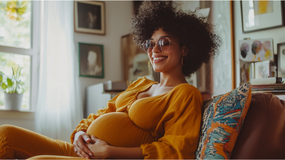 A pregnant woman sitting on her couch