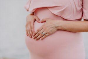 pregnant surrogate mother wearing pink dress for Made in the USA surrogacy agency in Bakersfield, CA