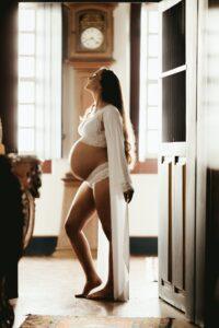 pregnant surrogate mother in Los Angeles standing indoors, courtesy of Made in the USA Surrogacy agency in California